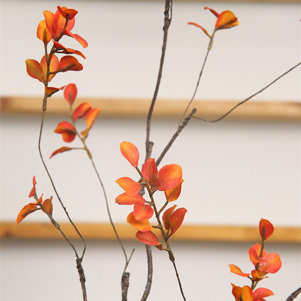 Feuilles et branches d'automne artificielles dans les couleurs du soleil couchant